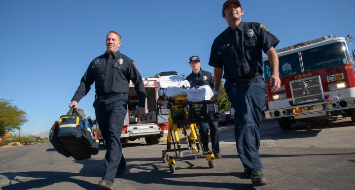Tucson medical responders wheel someone into the emergency room.