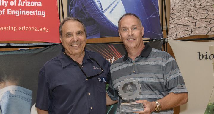 Ron Rich holds his Circle of Excellence Award while standing next to program director Ara Arabyan.