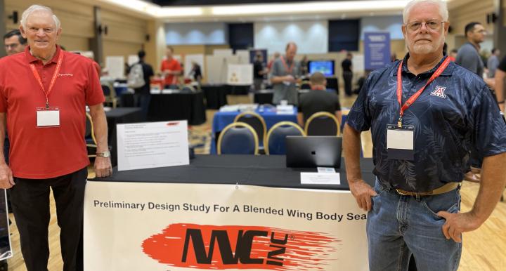 two people stand at a conference booth